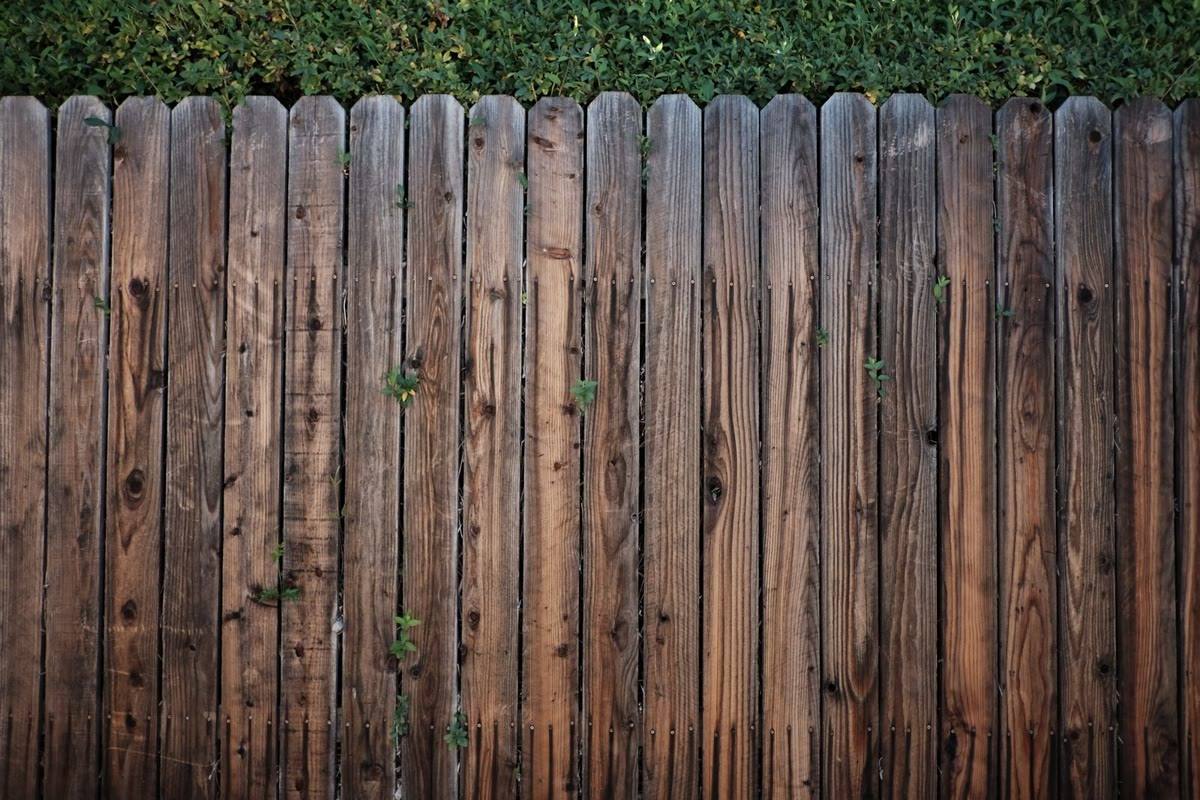 Weathered wooden picket fence in need of repair